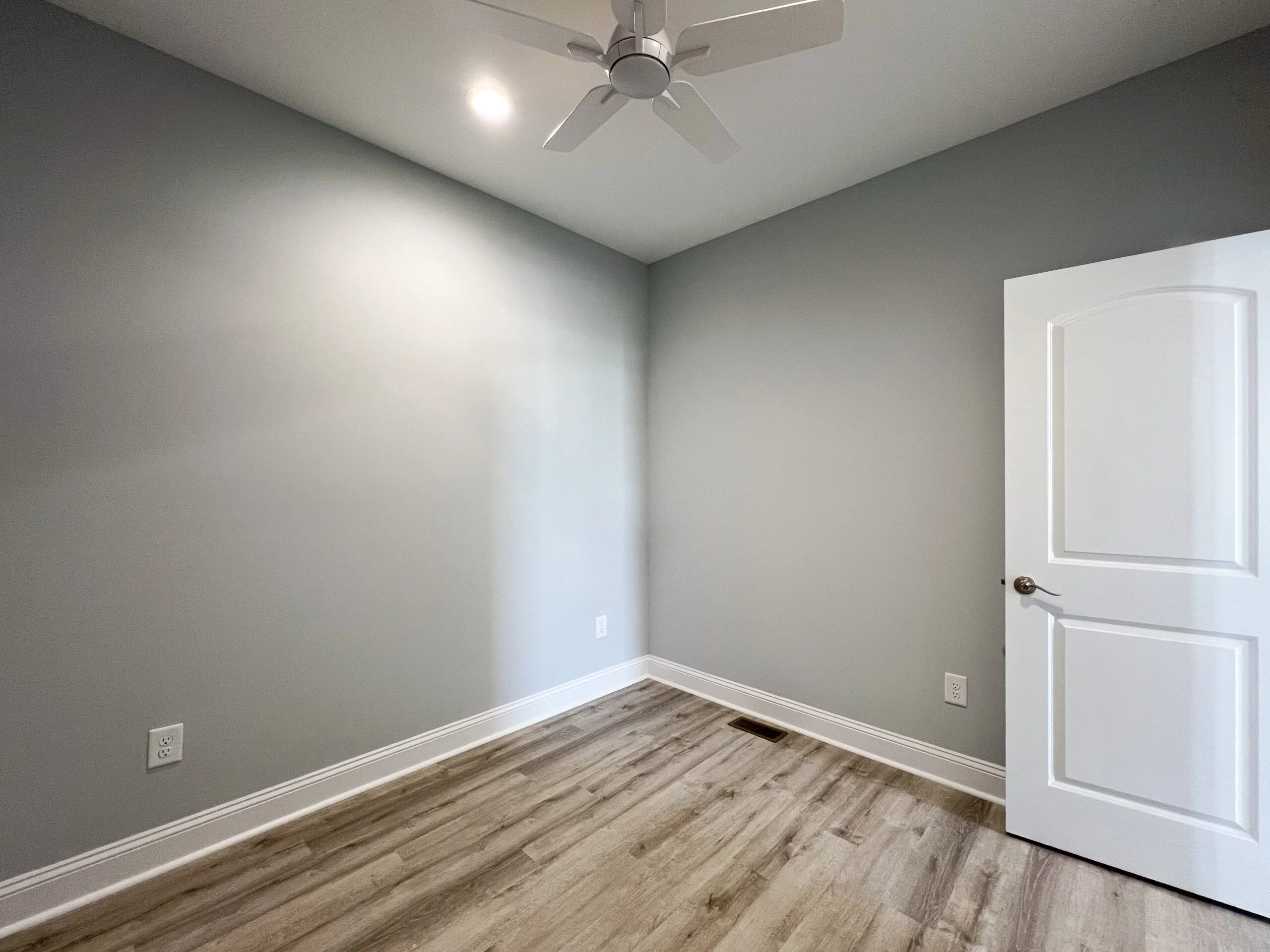 Gray painted walls, vinyl plank flooring, white trim, recessed lighting, and ceiling fan in finished interior room
