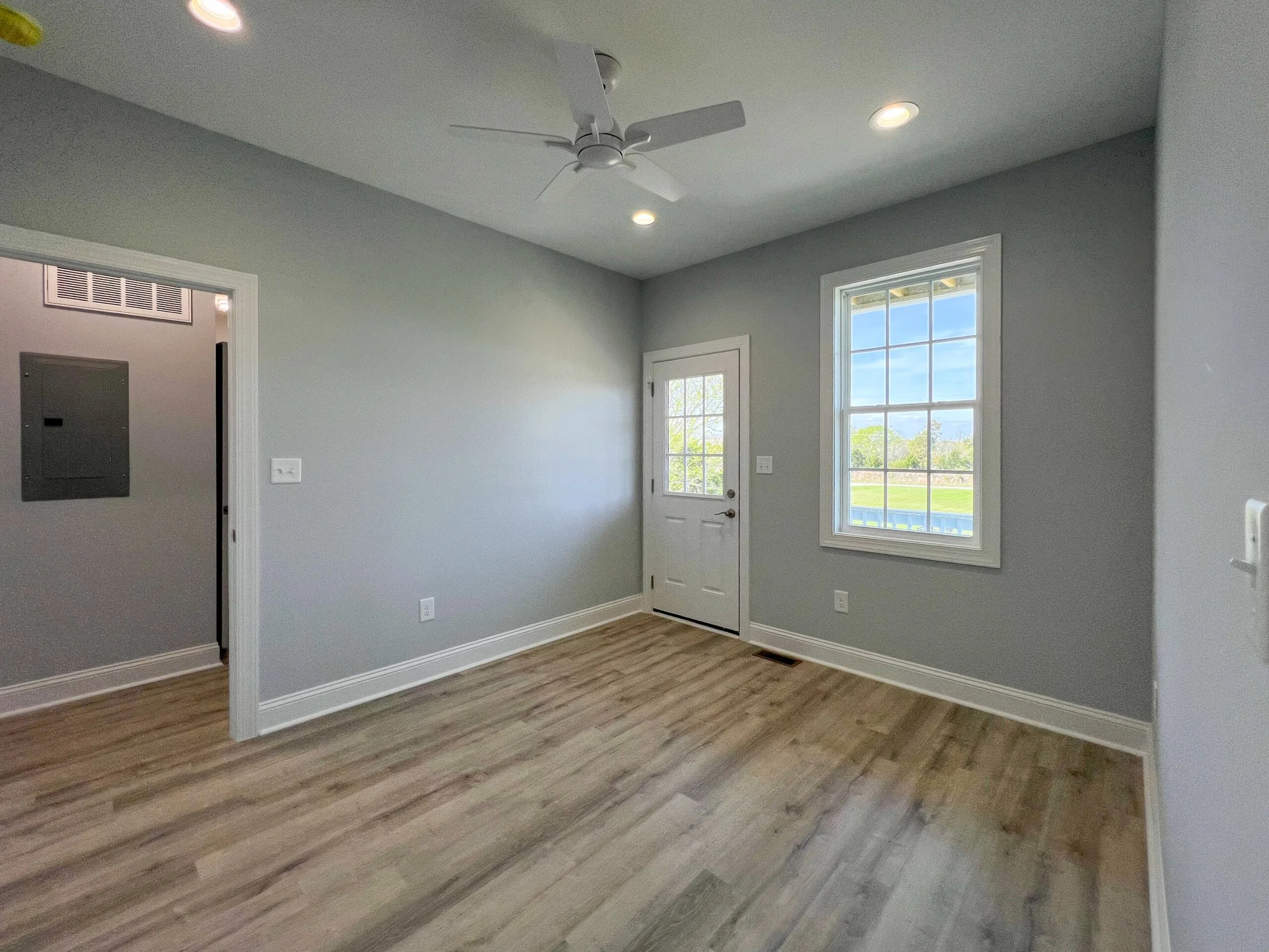 Gray painted room with vinyl plank flooring, white trim, recessed lights, and ceiling fan
