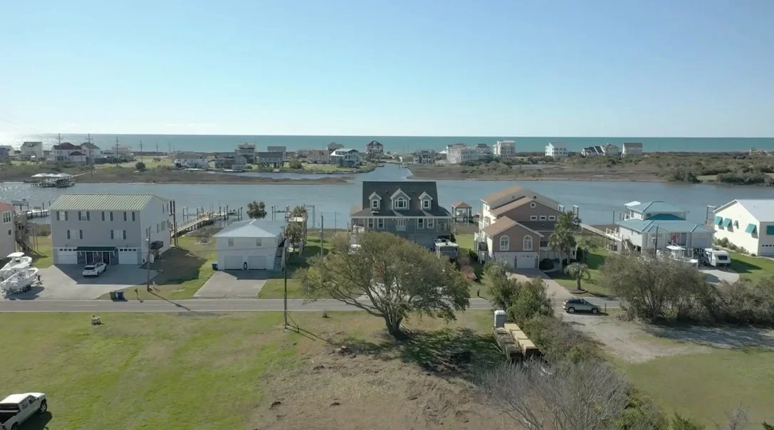Coastal home with well-maintained deck and landscaping overlooking waterfront in Sneads Ferry.